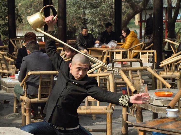 Un maître de thé verse le thé avec une bouilloire à long bec, dans une maison de thé de Chengdu
