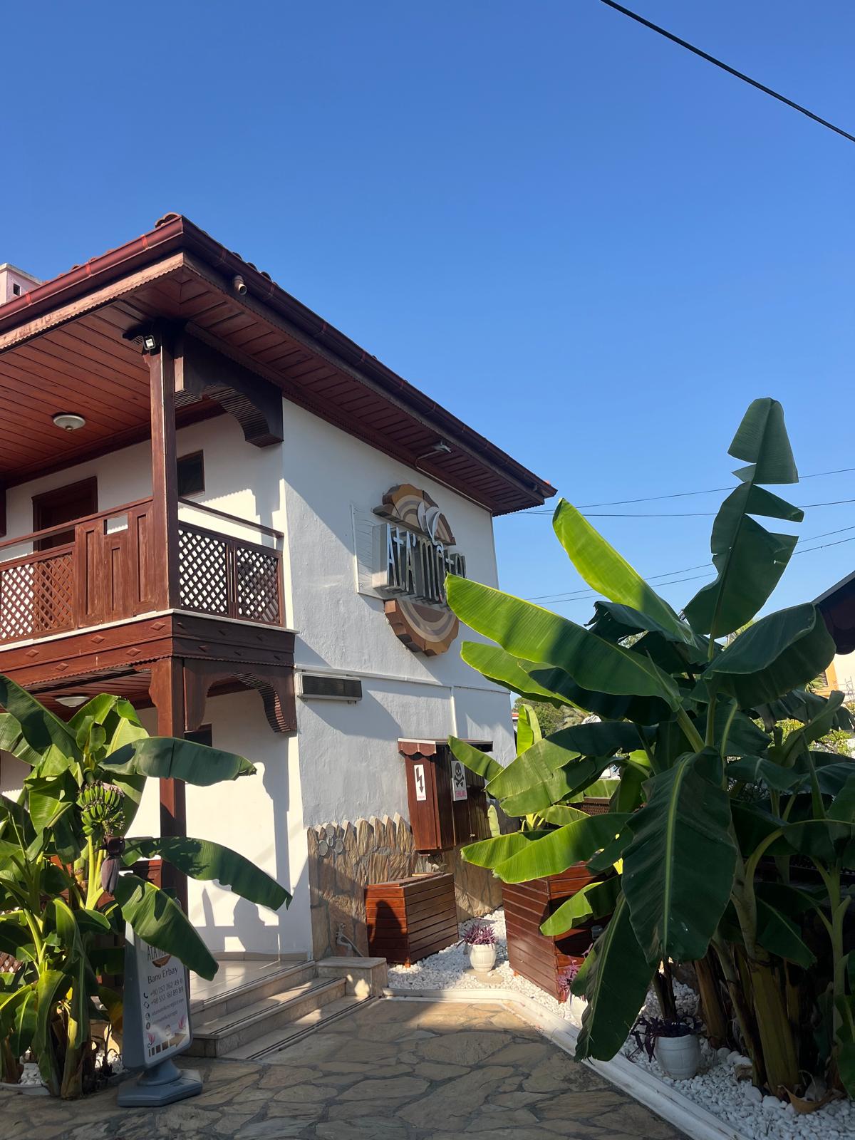 Façade de l’Ata Motel entourée de palmiers